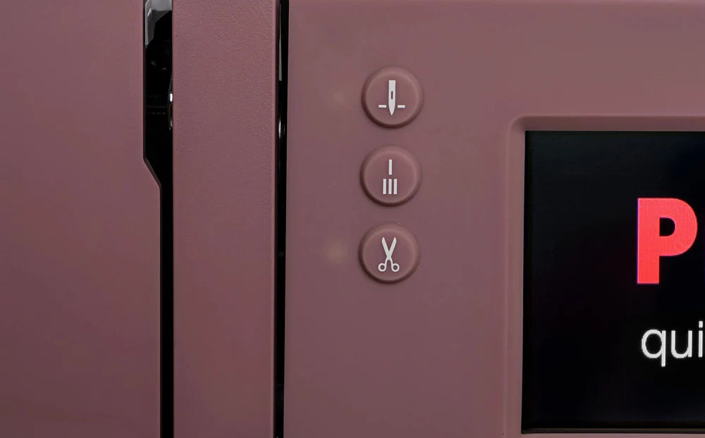 Close-up of three buttons on the Quilted Joy Pfaff Quilt Ambition 635 Sewing and Quilting Machine, showing icons of a paper stack, two lines, and scissors. Part of the screen with white and red text on black appears to the right.