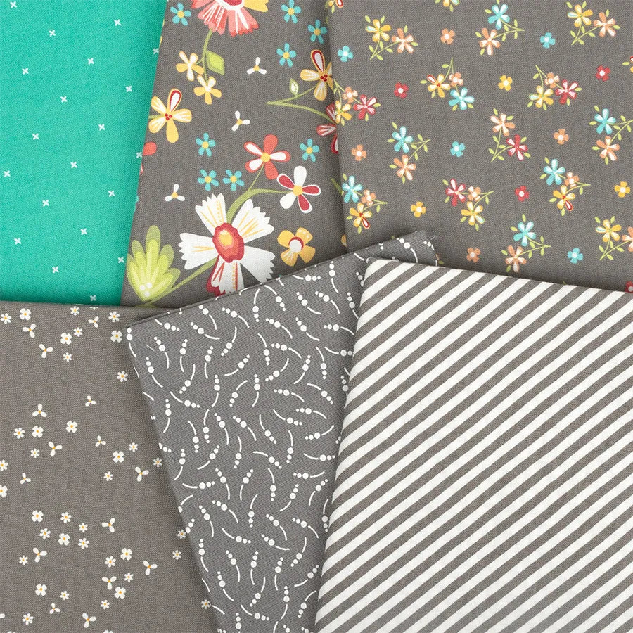 Five pieces of the "In The Garden Layer Cake" by United Notions feature patterns like colorful flowers, tiny white blooms, vines, dots on gray and teal, and gray stripes—perfect for your next Moda Fabrics project.