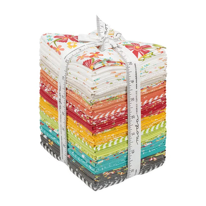 The In The Garden Layer Cake by United Notions features vibrant, floral and striped patterned squares neatly bundled with a measuring tape ribbon—perfect for quilting or any creative project.