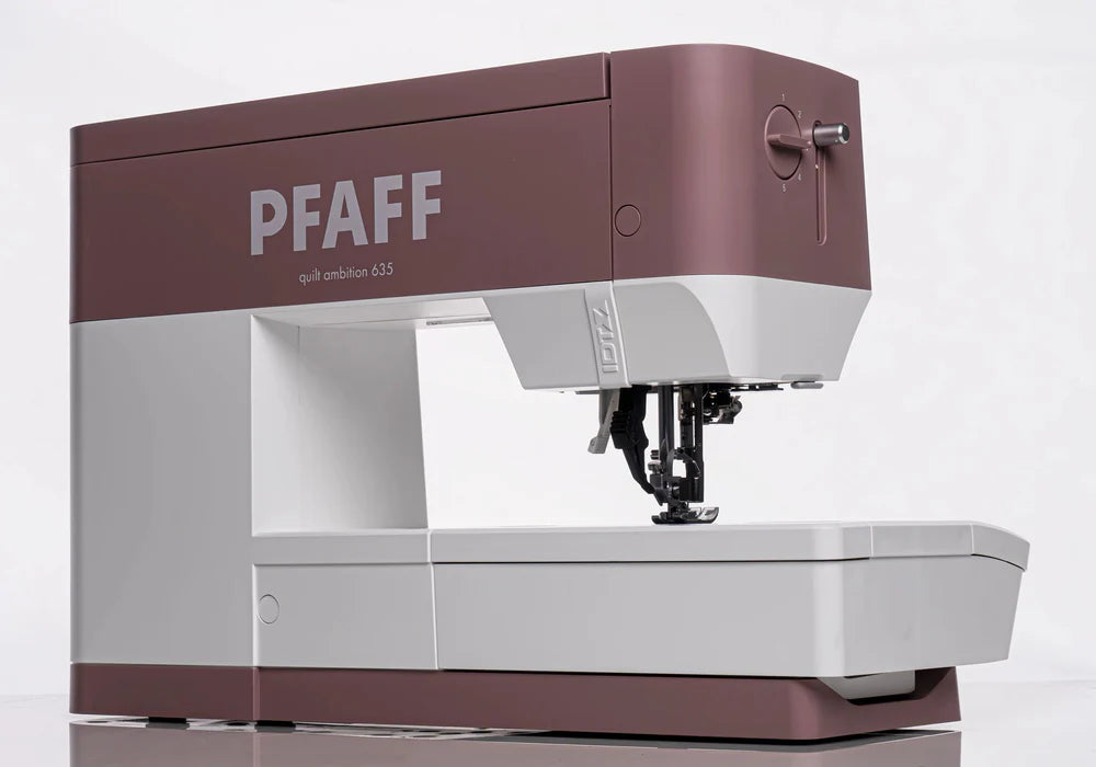 A Pfaff Quilt Ambition 635 Sewing and Quilting Machine by Quilted Joy in mauve and white, featuring Integrated Dual Feed Technology, viewed from the side against a plain white background.