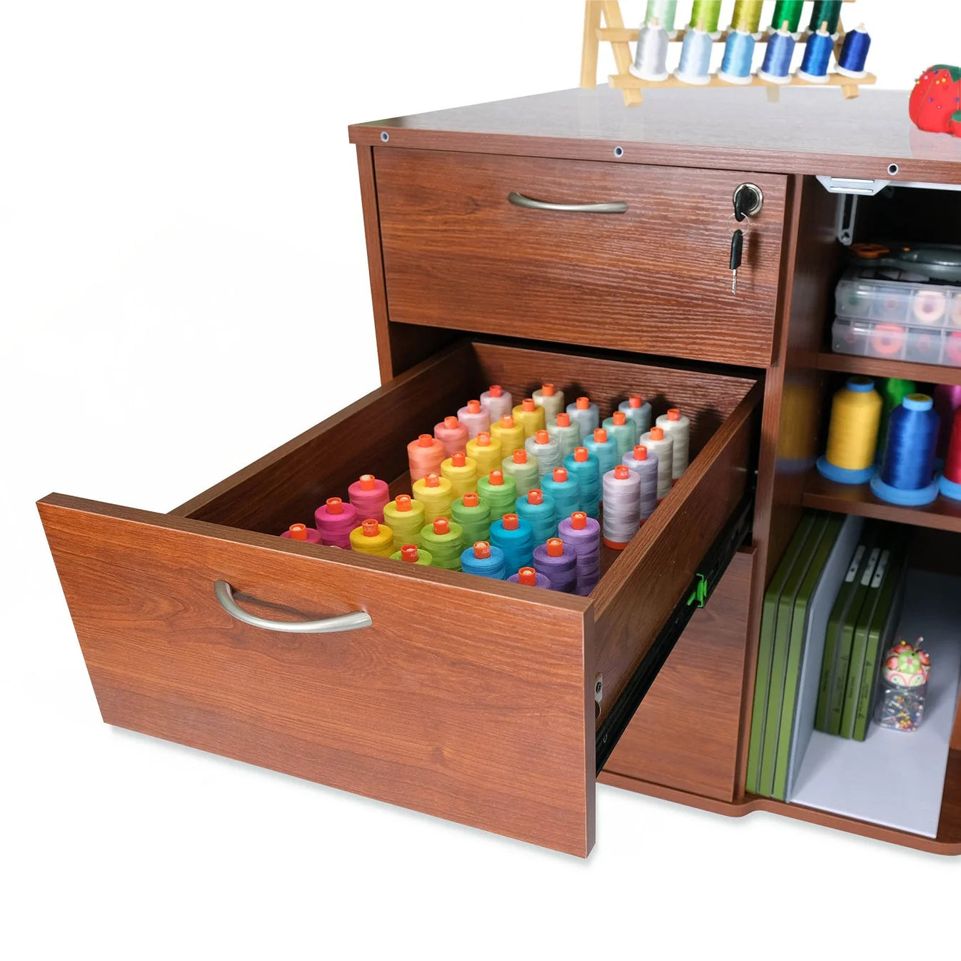 The Kangaroo Sydney Sewing Cabinet with Electric Lift by Arrow Companies, LLC features an open drawer displaying rows of colorful thread spools, with extra drawers and shelves storing sewing supplies and notions in the background.