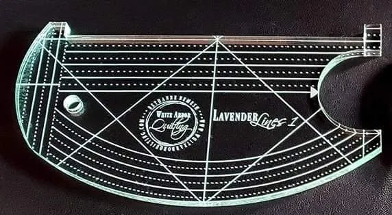 A transparent curved ruler from the Lilac & Lavender Duo Ruler Set by White Arbor Quilting features engraved measurements, a circular hole, and branded text, shown on a dark background.