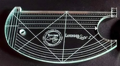 A transparent curved ruler from the Lilac & Lavender Duo Ruler Set by White Arbor Quilting features engraved measurements, a circular hole, and branded text, shown on a dark background.