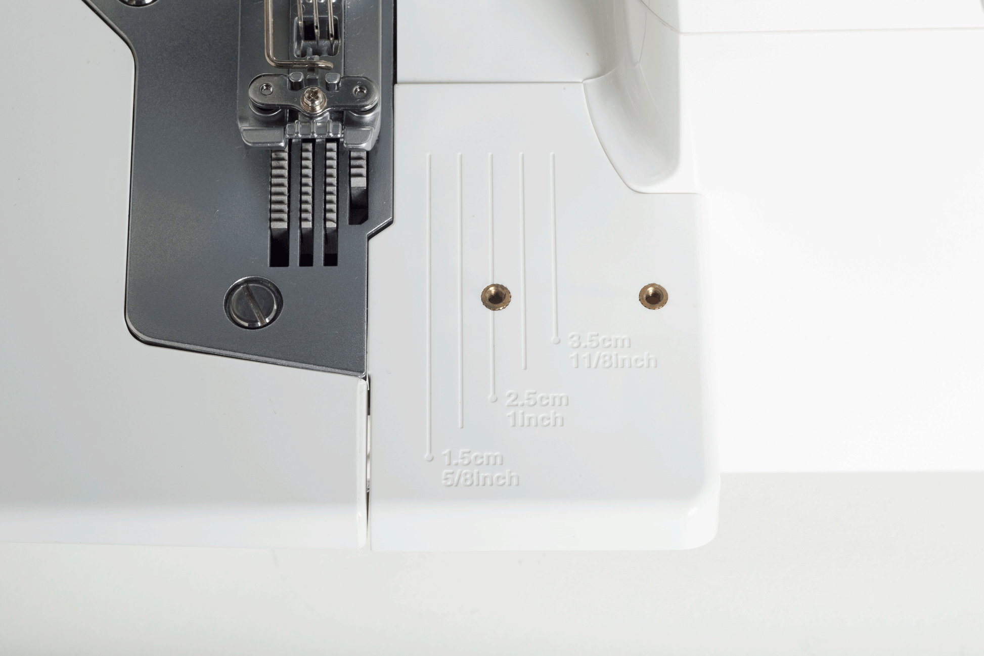 The three needles of the JUKI MCS-1700QVP above its extension plate, which is engraved with seam guidelines at 1.5cm, 2.5cm and 3.5cm.