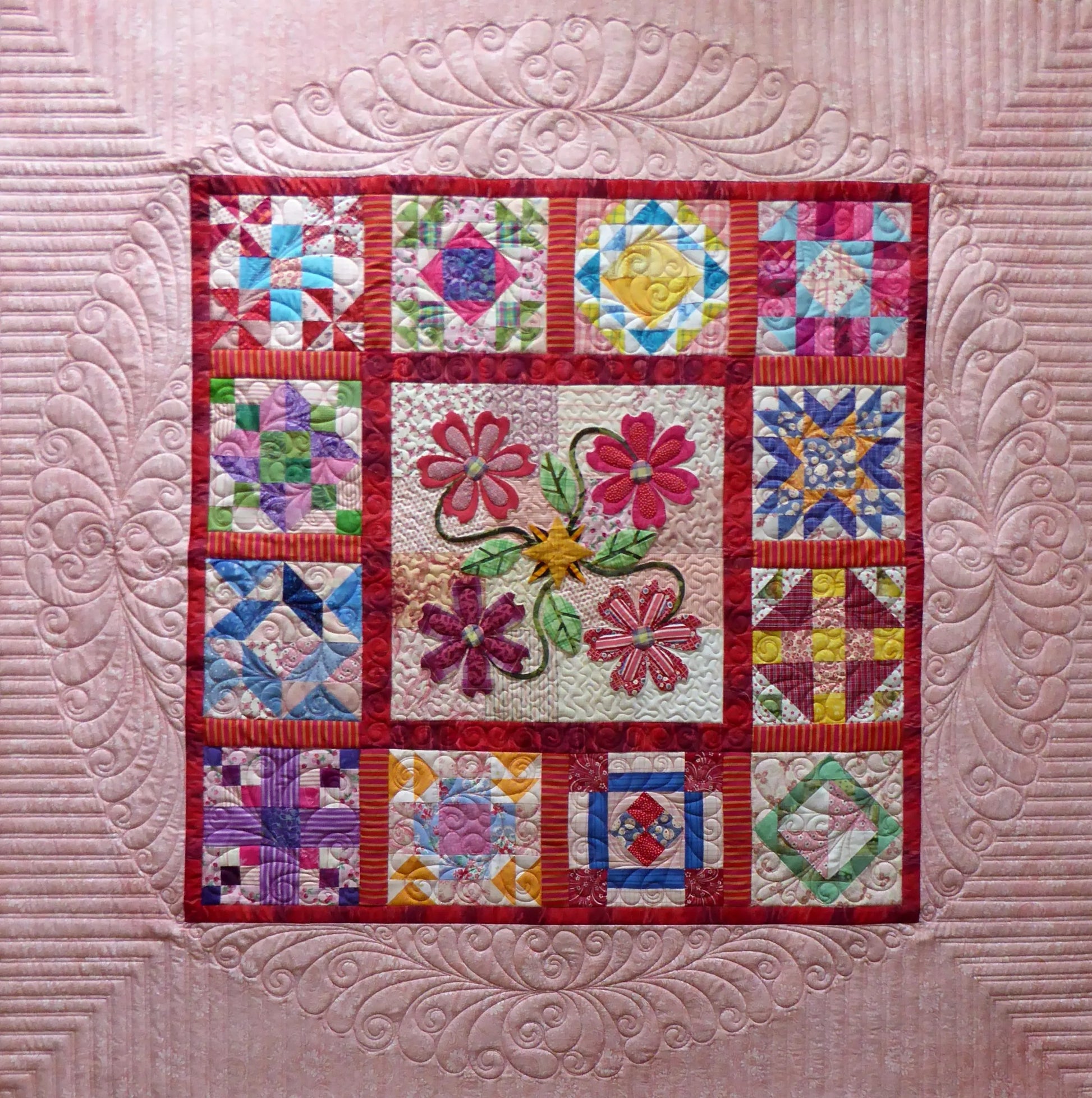 The Bethanne Nemesh Book Duo #1 by White Arbor Quilting showcases colorful sampler quilts with central floral panels, varied patchwork blocks, intricate pink borders, feather motifs, and decorative freemotion quilting designs.