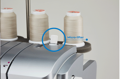 The micro-lifter lever on top of the JUKI Akane MO-3000QVP, circled and labeled, with thread cones standing behind it.