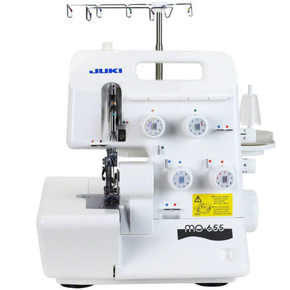 The Juki America Pearl Line MO-655 2/3/4/5 Thread Serger is a white overlock machine with multiple dials, thread holders, and a yellow warning label on the front, photographed against a white background.