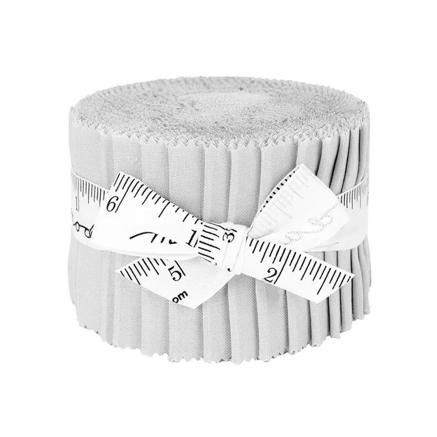 A Bella Solids Zen Gray Junior Jelly Roll by United Notions—fabric strips neatly rolled and tied with a white measuring tape ribbon—rests on a plain white background, ideal for quilting projects.