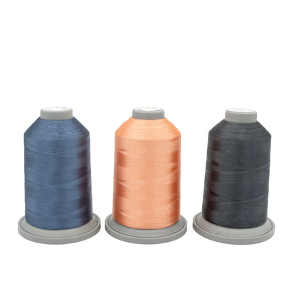 The Moonlight Tides Glide Thread of the Month Bundle by Hab+Dash by Fil Tec features three large spools in blue, peach, and dark gray on gray bases, arranged side by side—ideal for embroidery or quilting projects.