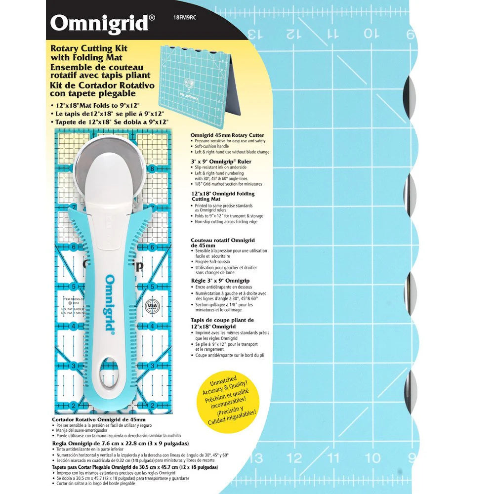 The Omnigrid 12 x 18 Compact Rotary Cutting Kit by Tacony Corporation includes a turquoise folding mat with a light blue grid, an ergonomic 45mm rotary cutter, and ruler. Multilingual product info is printed on the left side of the packaging.