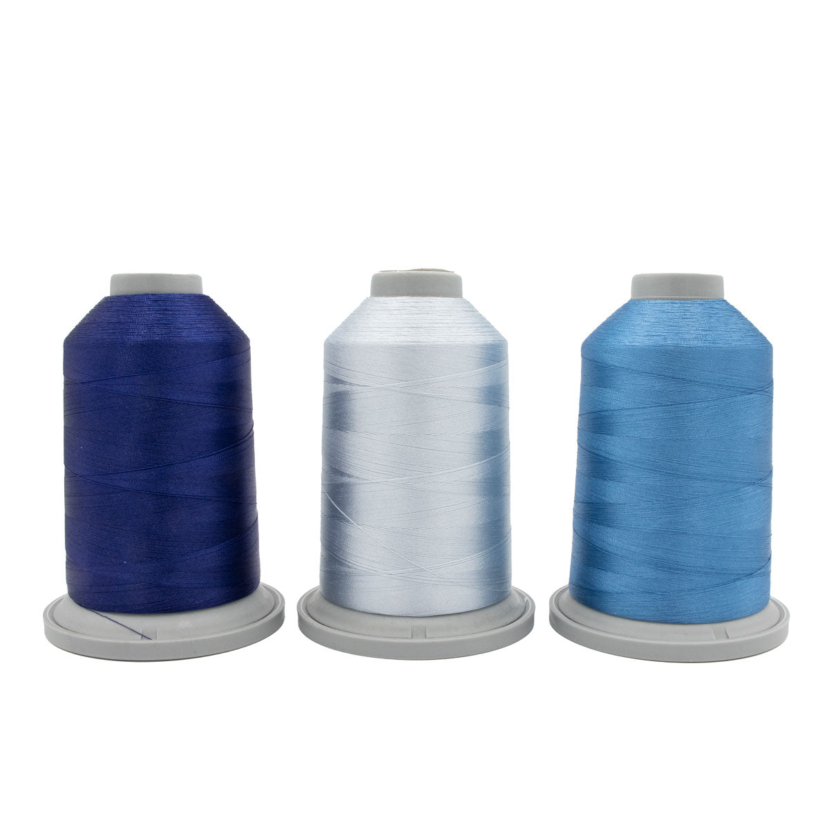 Three large spools of Hab+Dash Polar Prism Glide Thread of the Month Bundle in navy blue, white, and light blue are arranged side by side on gray bases against a plain white background—perfect for quilting or embroidery.