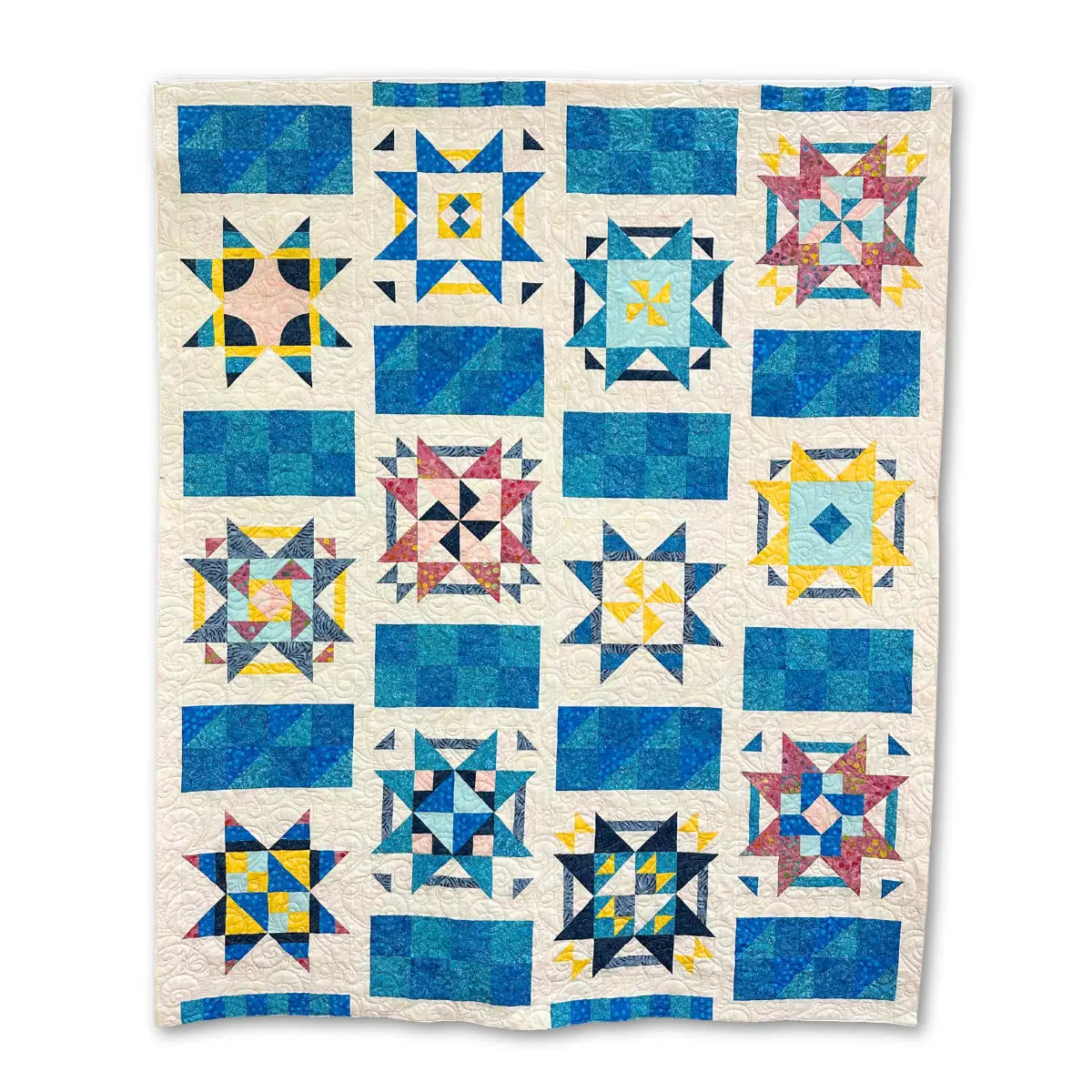 The Quilt Fairy Dreams Quilt Kit includes materials to make a handmade star quilt with a grid of colorful stars and geometric patterns in blue, yellow, pink, and white—ideal for any collection.