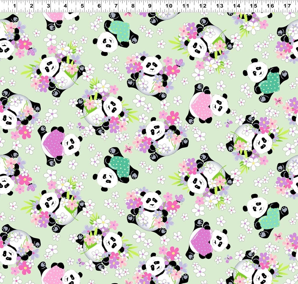 Panda Party Soft Green Tossed Pandas Fabric Yardage by Clothworks Fabric features adorable green pandas in colorful shirts among pink, white, and purple flowers on a light green background—ideal for nursery quilting. Ruler at top shows inch scale.