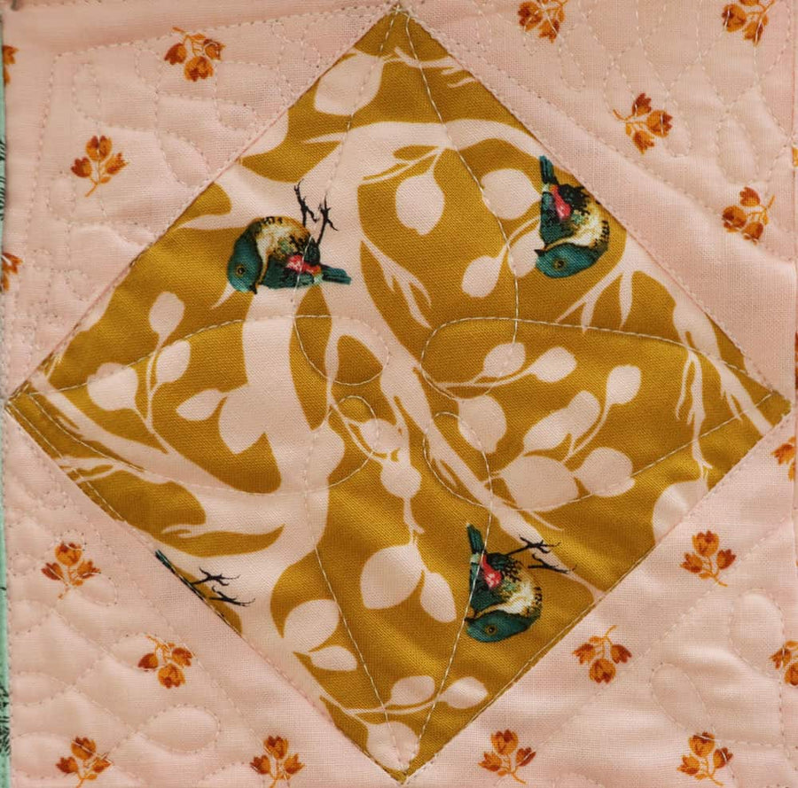 Square-in-a-square quilt block with loopy quilting