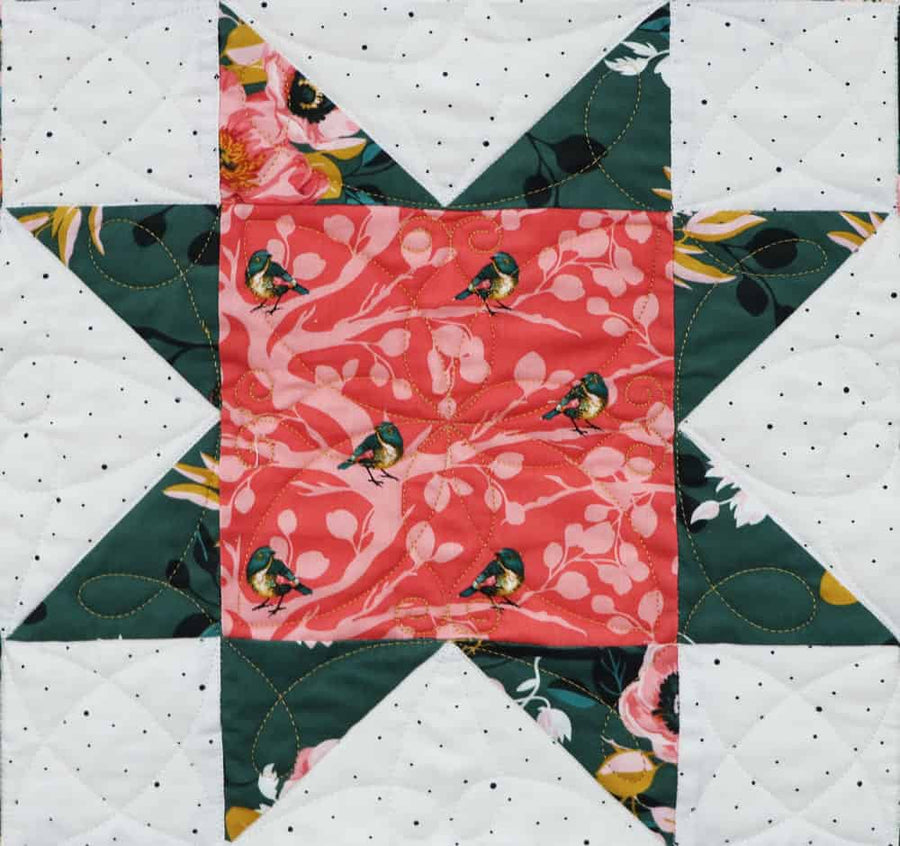 Floral star quilt block with feather quilting