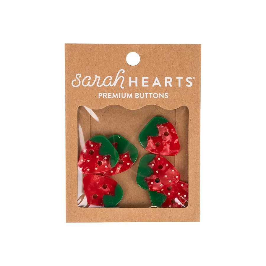 Four red and green 1" Large Strawberry Buttons by Checker Distributor come in a brown cardboard package with a clear window—plant-based acetate and perfect for sewing accessories.