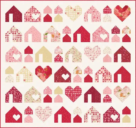 The Heartfelt Homes Quilt Kit by Quilted Joy features houses and hearts in red, pink, cream, and florals on white—perfect for showcasing your Darling Peony Layer Cake in a charming, organized design.