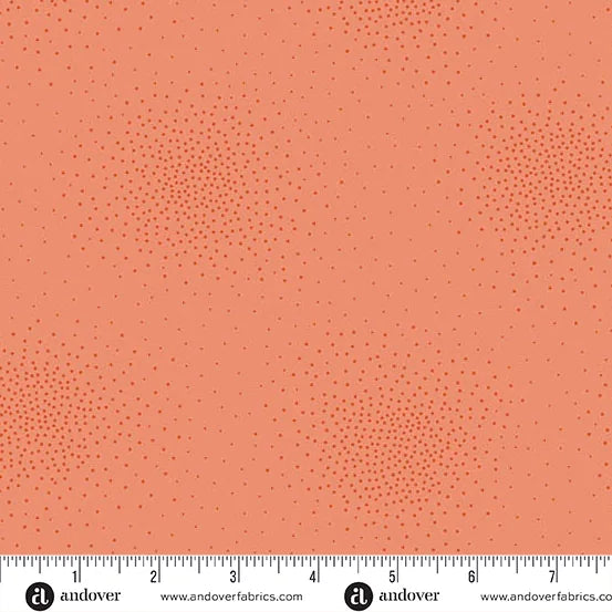 Spritz Coral Fabric Yardage by Andover features a subtle pattern of small, scattered darker coral dots in clusters. An inch ruler is shown along the bottom edge for scale.