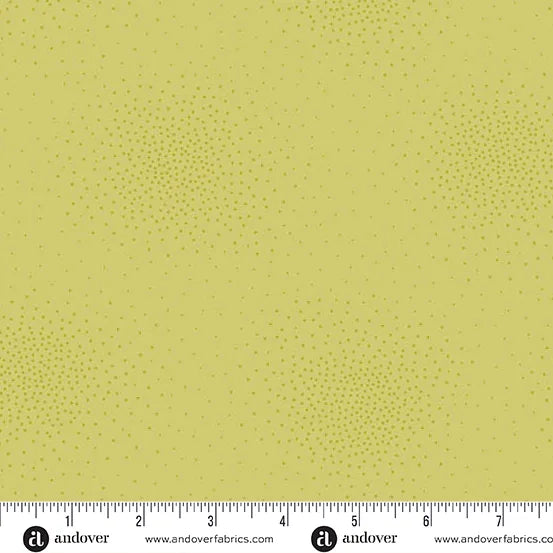 Spritz Granny Smith Fabric Yardage by Andover features pale yellow quilting fabric with subtle, scattered small green dots, creating a soft, textured look. A ruler below shows inches from 0 to 9 and the Andover brand is visible.