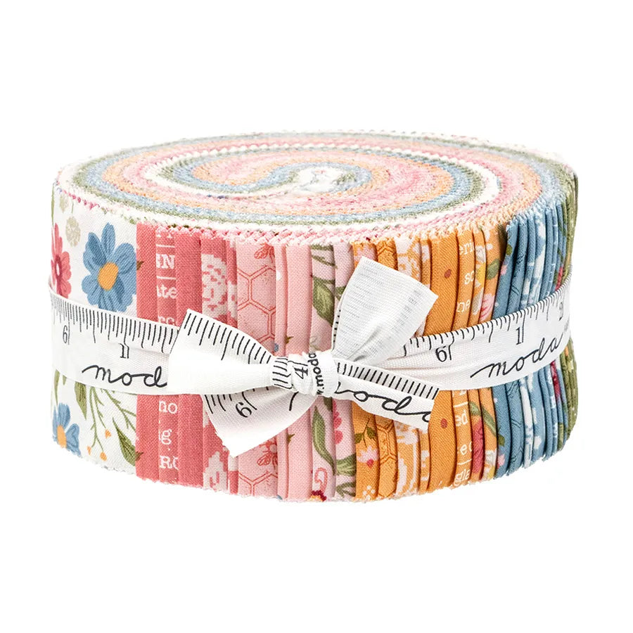 A rolled bundle of United Notions’ Wild Honey Jelly Roll precut fabric strips, wrapped in a white measuring tape, includes floral and geometric designs in pastel and warm tones.