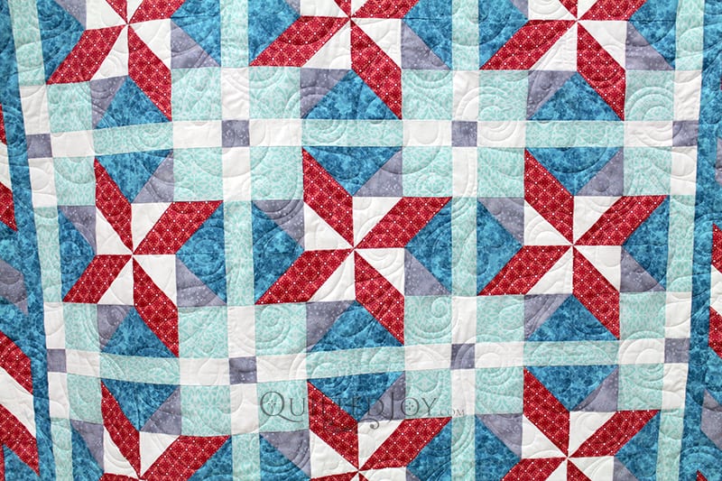 What's not to love about an easy, breezy quilt for summer or spring? Jodi's fun pinwheel stars quilt looks so fun with bright colors and a fun floral and swirly pantograph quilting design.