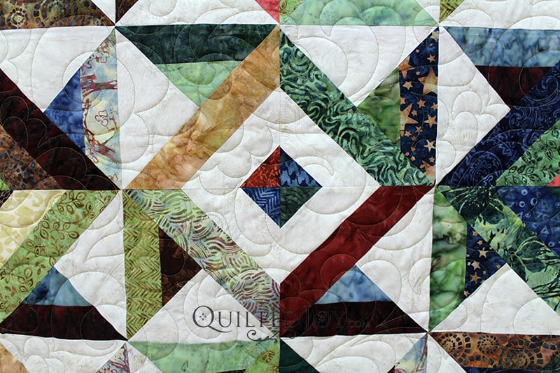 Judy brought me this beautiful quilt with pinwheel blocks and concentric squares made of beautiful batik fabrics. This was calling for a lovely pantograph with lots of movement.