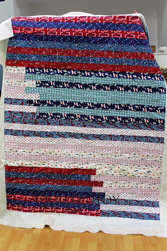 This is a jelly roll race quilt. It can be pieced in about an hour. Judy made this for a coworker who loves dogs. If you look carefully her jelly roll had a lot of dog prints. What a thoughtful gift for a friend!