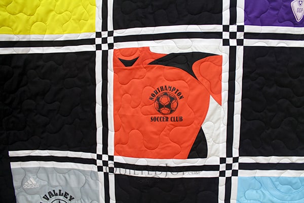 Sue asked me to quilt this awesome soccer jersey quilt! I was so impressed with the way she played with the sashing and cornerstones, and how she cut some of the jerseys in really surprising ways.