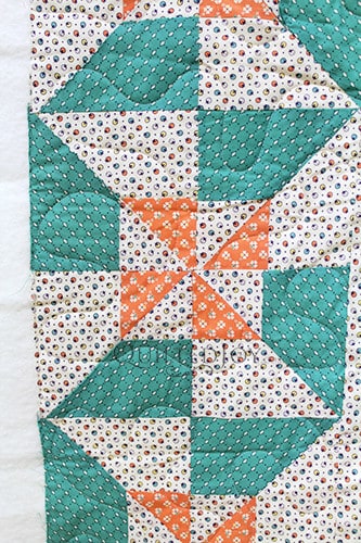 Vintage inspired pinwheel block variation quilt in cream, green, and orange colors