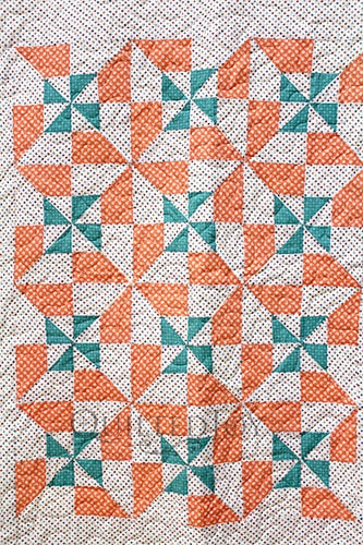 Vintage inspired pinwheel block variation quilt in cream, green, and orange colors
