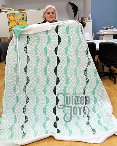 Karen's minty green quilt after longarm quilting it at Quilted Joy