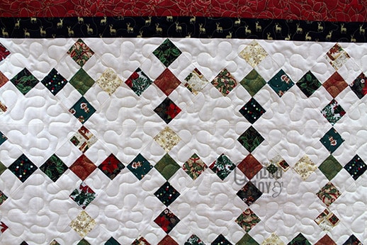Carol's Christmas themed Irish Chain quilt after quilting it at Quilted Joy