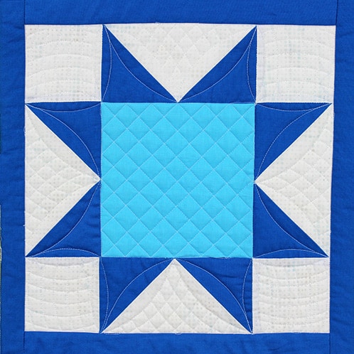 Sawtooth Star quilt block with crosshatching quilting