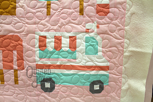 Colleen shows off her Sweet Treat Quilt after longarm quilting it at Quilted Joy