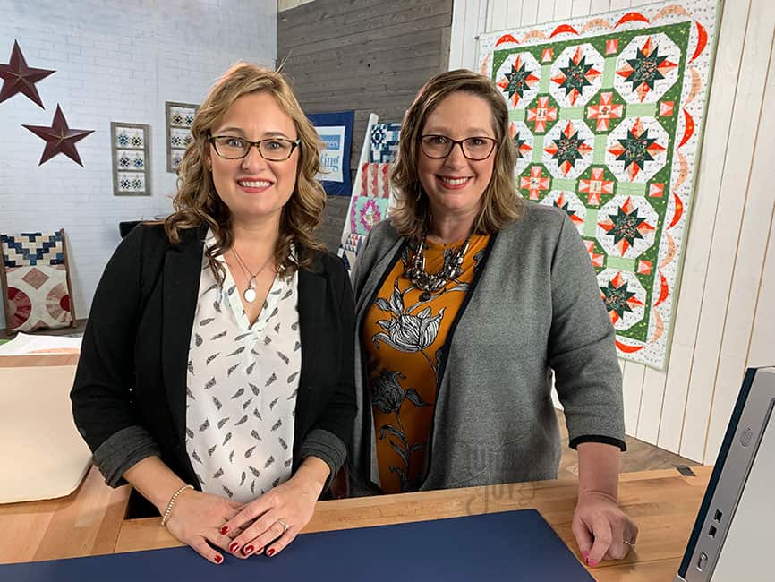 Angela Huffman on the set of Love of Quilting with Co-host Sara Gallegos and her quilt Forest Jubilee in the background