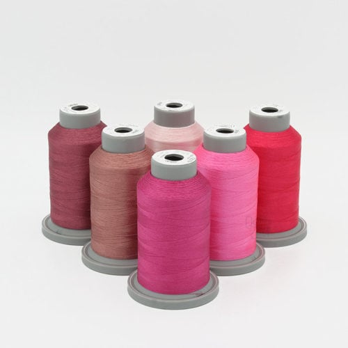 image of six cones of pink Glide thread on a white background