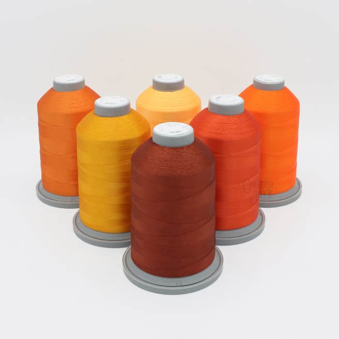 Glide Thread Color Block Bundle - Orange - six cones of orange Glide thread on a white background