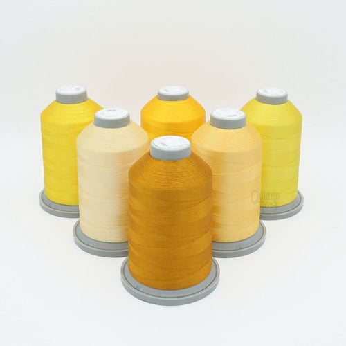 image of six cones of yellow Glide thread on a white background