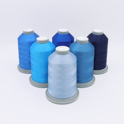 image of six cones of blue Glide thread on a white background